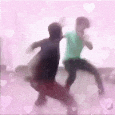a blurry picture of two people dancing on a pink background with hearts .