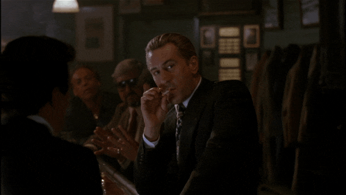 a man in a suit and tie smoking a cigarette
