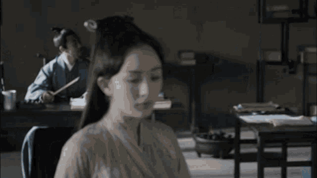 a man and a woman are sitting at a table in a library .