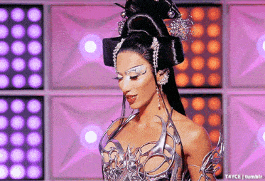 a woman with a very elaborate hairstyle is wearing a silver and black dress