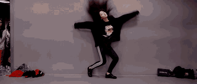 a girl is doing a split in front of a wall with a bag that says brooklyn on it