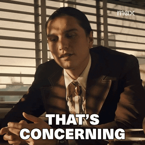 a man in a suit and tie is sitting at a table and says that 's concerning