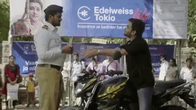 a man is standing next to a motorcycle and talking to a police officer