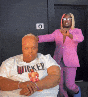 a man in a pink suit is standing next to a woman in a wicked shirt