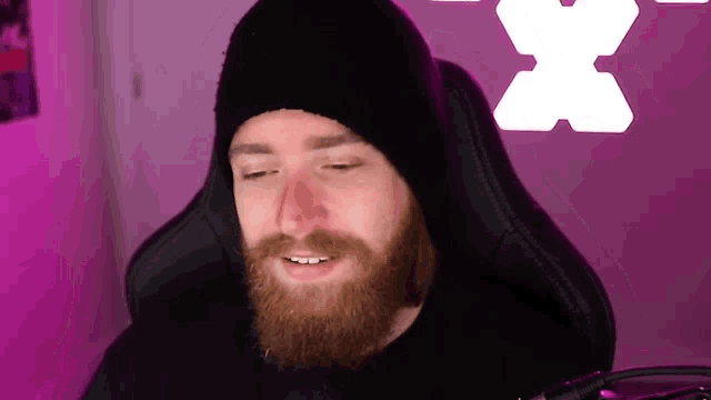 a man with a beard wearing a black hat and a black shirt