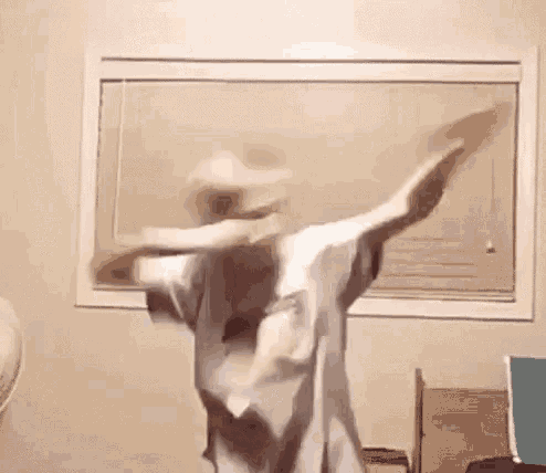 a person is dancing in a room in front of a window .