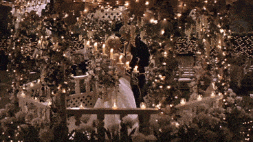 a bride and groom are kissing under a gazebo decorated with flowers and lights