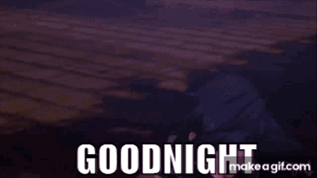 a person is laying on a bed with a purple sheet and the words `` goodnight '' written on it .