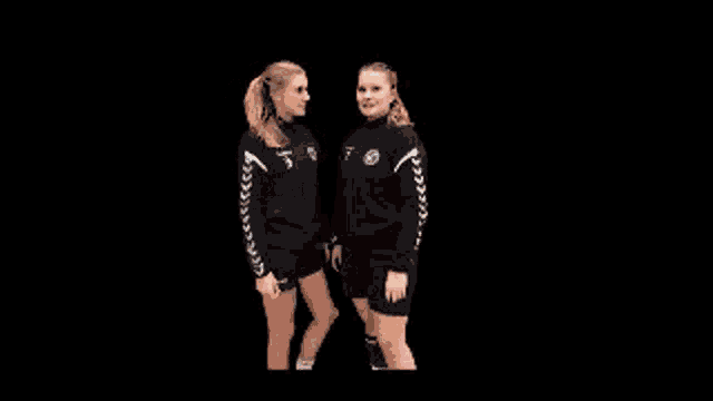 two female athletes are standing next to each other on a black background