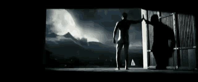 a naked man is standing in a dark room