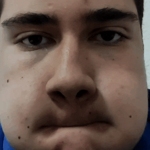 a close up of a man 's face with a slight smile on his face