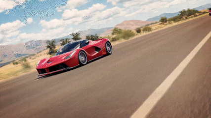 a red sports car is driving down the road