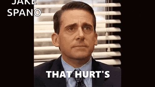 a man in a suit and tie is sitting in front of a window with blinds and the words `` that hurt 's '' .