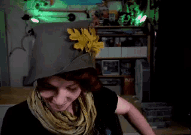 a woman wearing a scarf and a hat with a flower on it