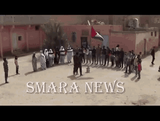 a group of people standing in front of a pink building with the words smara news written on the bottom