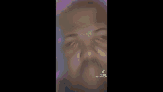 a close up of a man 's face with his eyes closed and a yellow glow around his head .