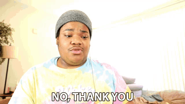 a man wearing a tie dye shirt and a beanie says no thank you
