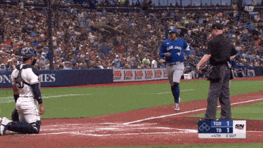 a blue jays player runs to home plate during a game
