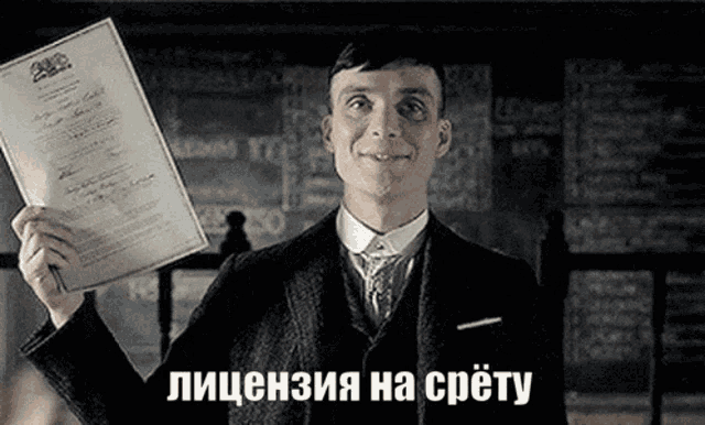 a man in a suit and tie is holding a piece of paper in his hand with a caption in russian