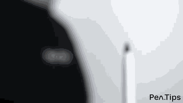 a person is standing in front of a computer monitor with a pen in front of it .
