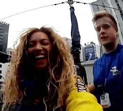 a woman wearing a yellow jacket that says ' tommy hilfiger ' on it
