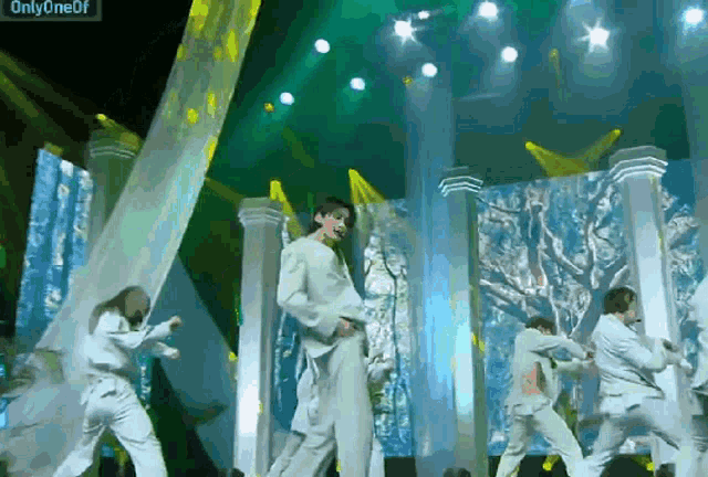 a group of people dancing on a stage with the words onlyoneof on the bottom