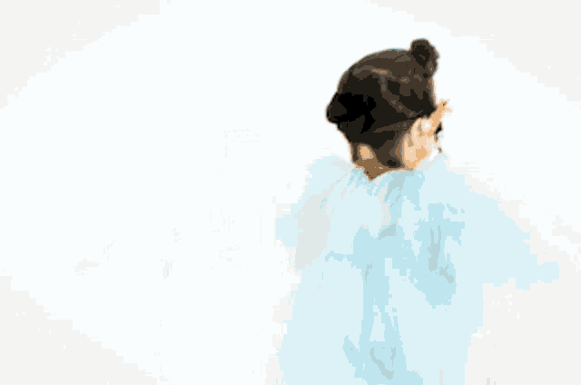 a woman wearing a blue tulle dress with a bun in her hair