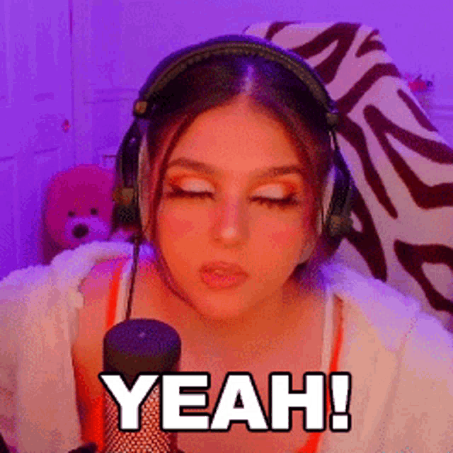 a woman wearing headphones is saying yeah