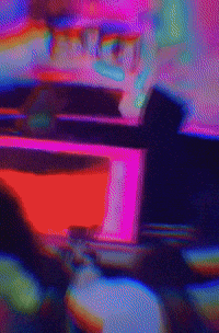 a blurry picture of a person playing a video game in a neon room .