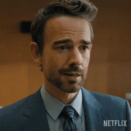 a man in a suit and tie has a netflix logo on his jacket