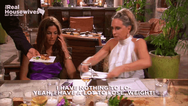 two women are sitting at a table with a sign that says real housewives out of context