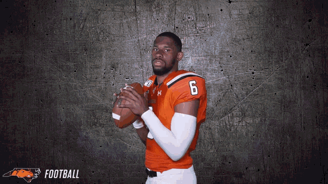 a football player with the number 6 on his jersey holds a football