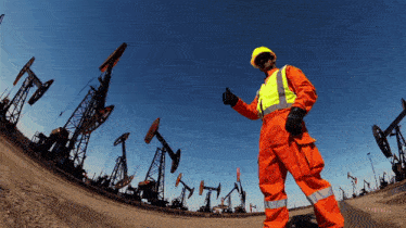 a man in orange overalls is giving a thumbs up