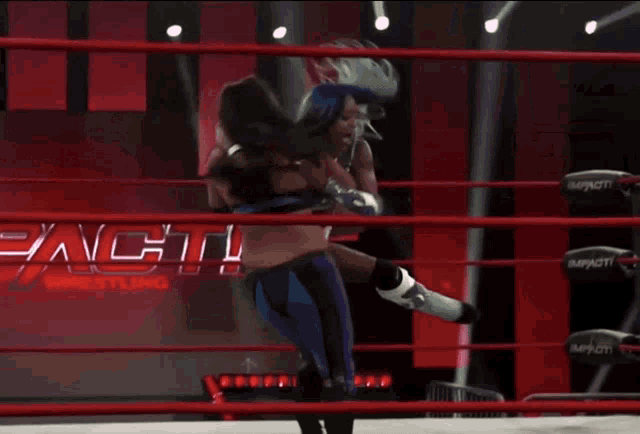 two wrestlers in a ring with a sign that says impact on it