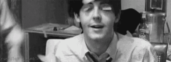 a black and white photo of a man wearing a tie and a shirt .