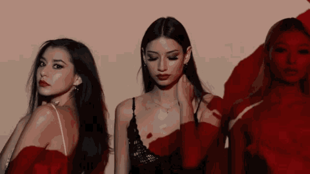 three women standing next to each other with red shadows on them