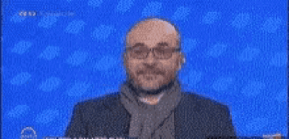 a man wearing glasses and a scarf is making a funny face .