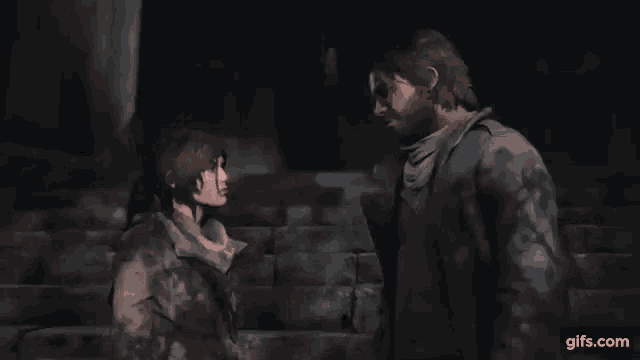 a man and a woman are standing next to each other in a dark room .