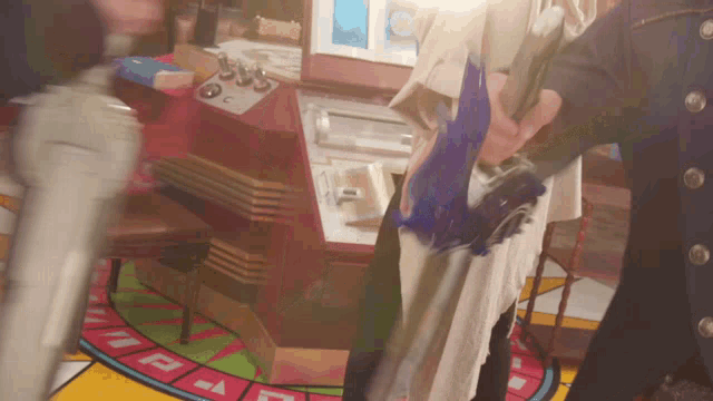 a man in a white coat is standing in front of a roulette wheel that says a on it