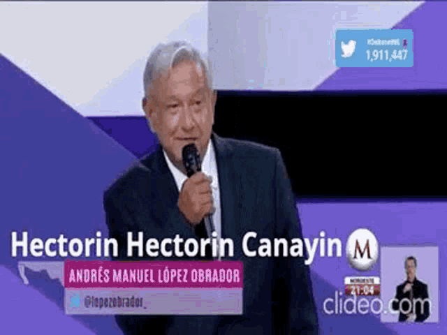 a man in a suit and tie is holding a microphone and speaking into it .