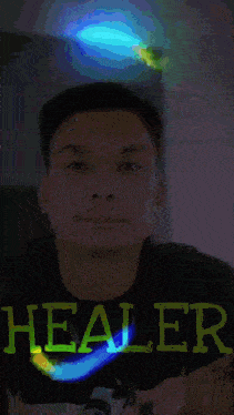 a man wearing a shirt that says healer on it