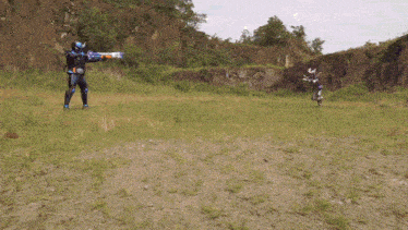 a man in a superhero costume is holding a gun in a grassy field