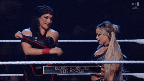 two women are dancing in a wrestling ring with the letters w on the bottom