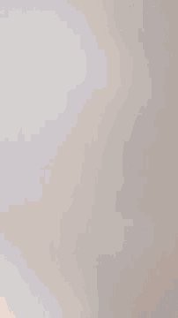 a person 's finger is pointing at a small white device on the ceiling
