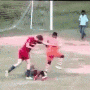 two soccer players are fighting on a field and one of them is wearing a red shirt