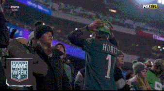a group of people watching a football game with the score 28 13