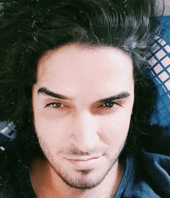a close up of a man 's face with long hair and a beard