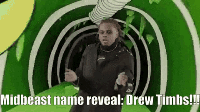 a man is dancing in a green tunnel with the words midbeast name reveal drew limbs
