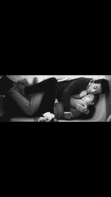 a black and white photo of a man and woman hugging each other