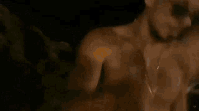 a man without a shirt is being held up by another man .
